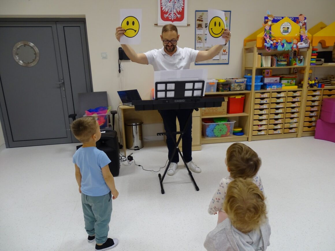 Pan pokazuje dzieciom buzię smutną i wesołą