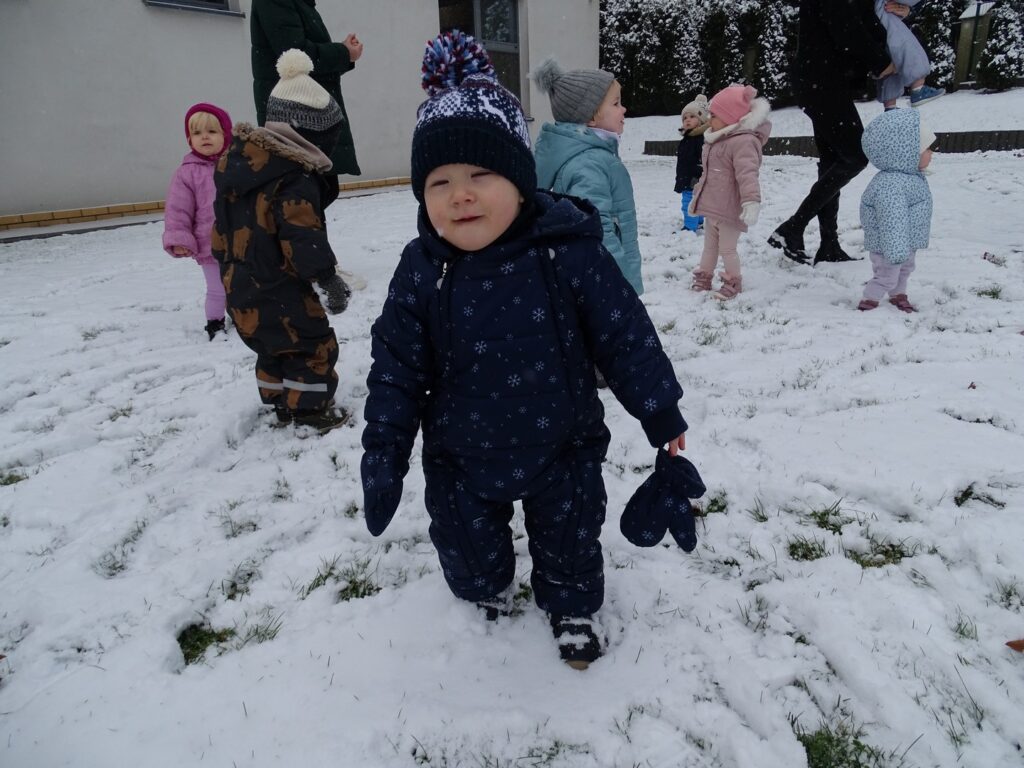 Chłopczyk bawi się na śniegu