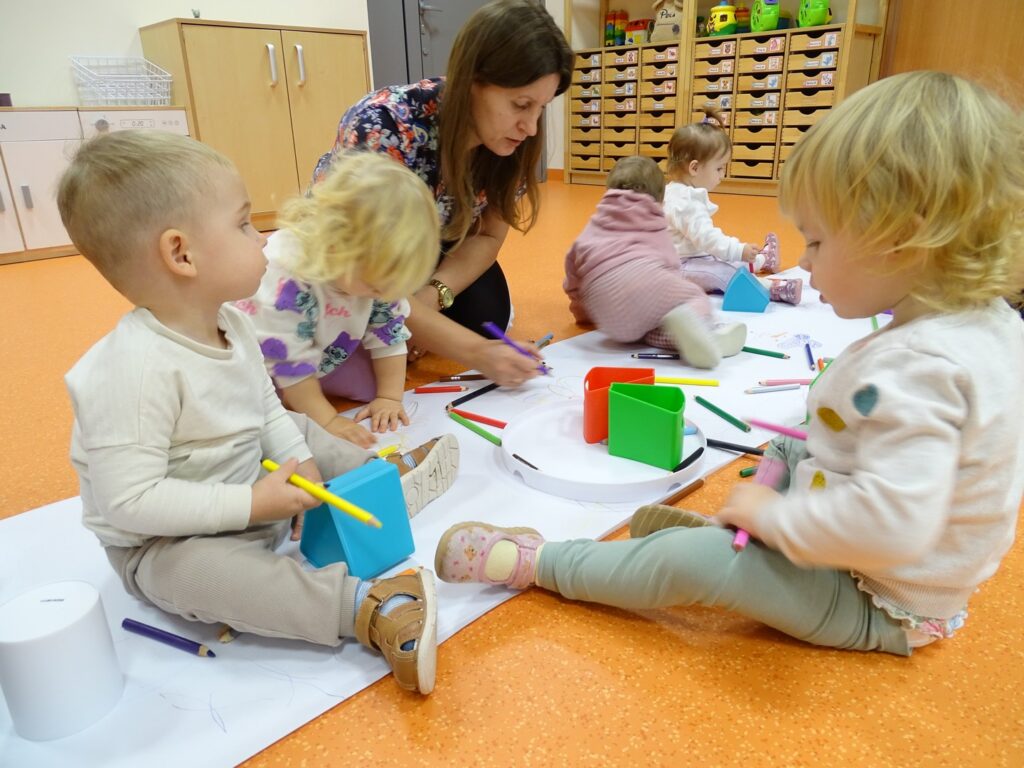 Opiekun maluje z dziećmi