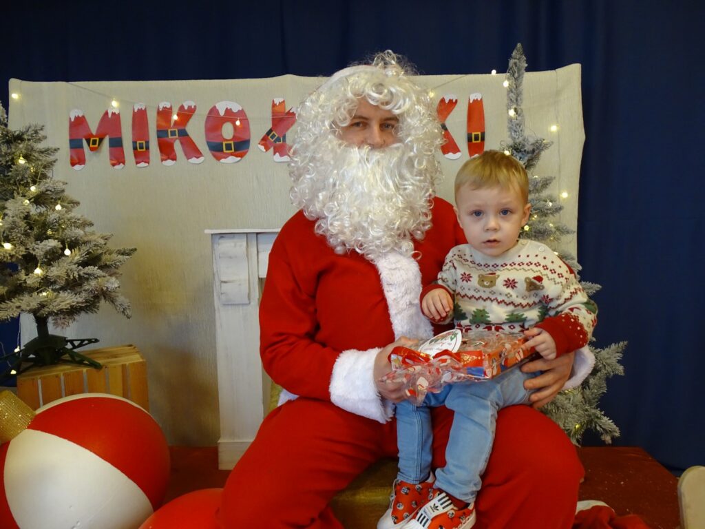 Chłopczyk pozuje do zdjęcia z Mikołajem