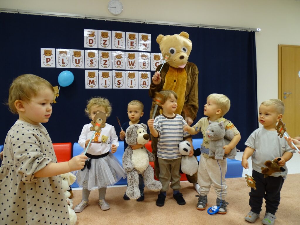 Dzieci pozują do zdjęcia z misiem