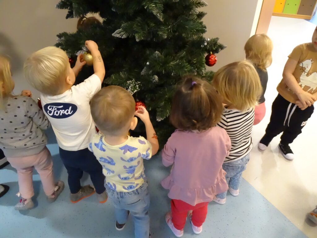 Dzieci wspólnie ubierają choinkę