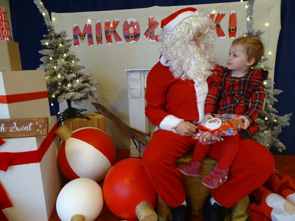 Dziewczynka pozuje do zdjęcia z Mikołajem