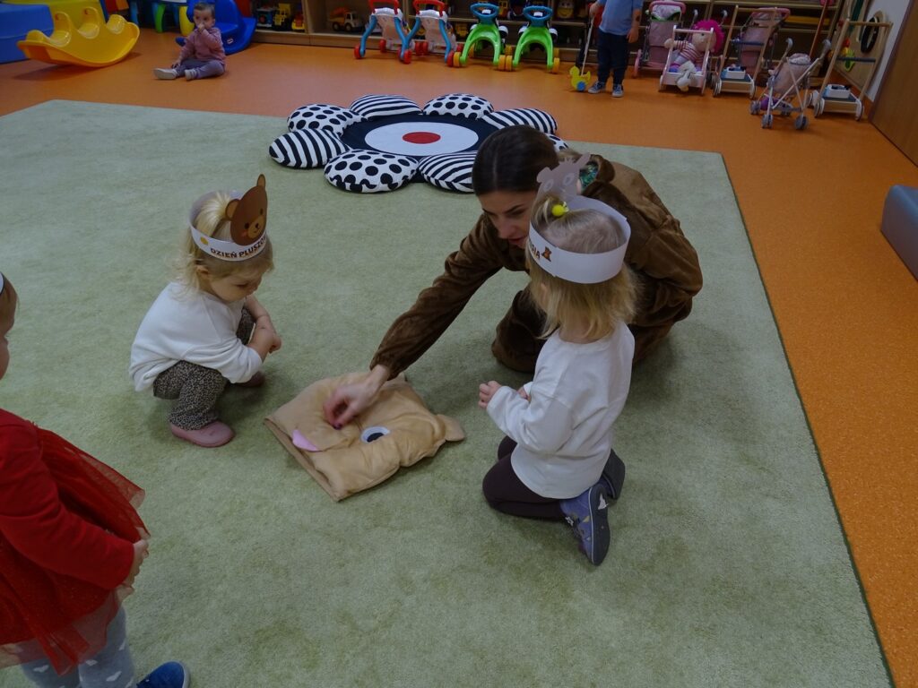 Miś i dzieci na dywanie