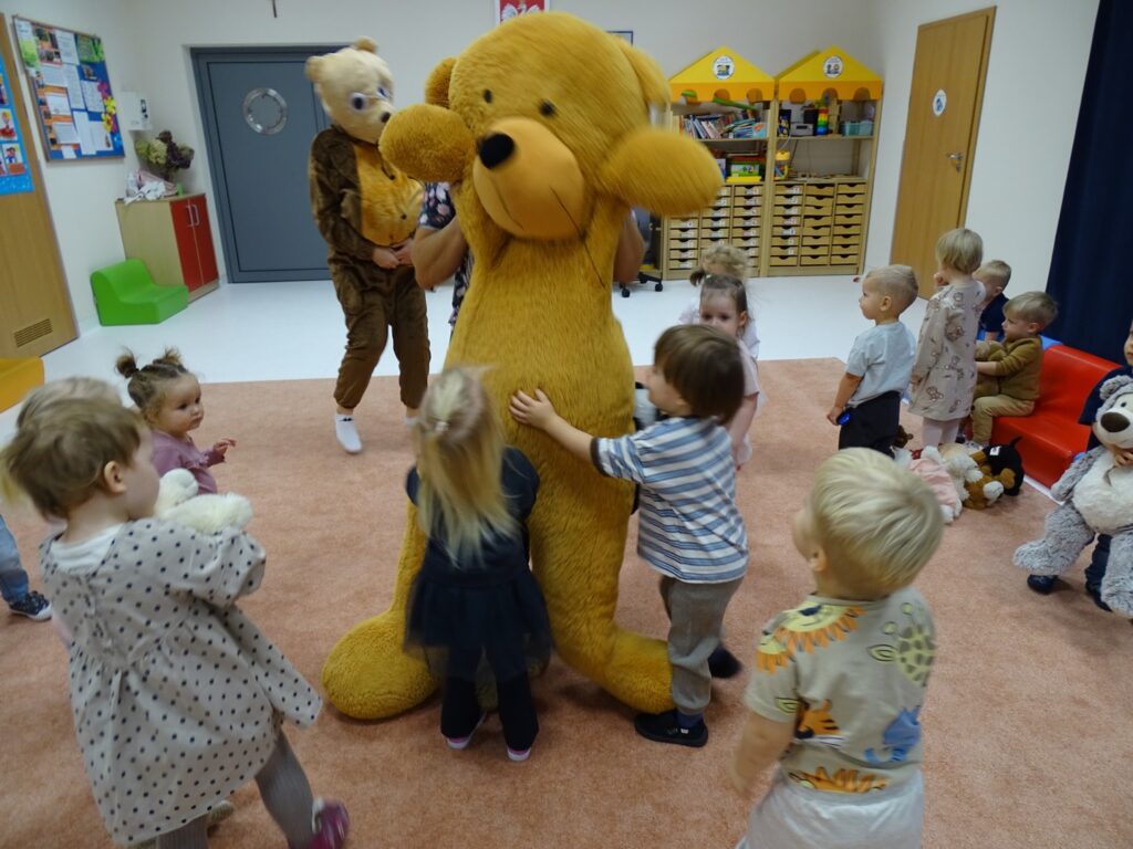 Dzieci bawią się z pluszowym misiem