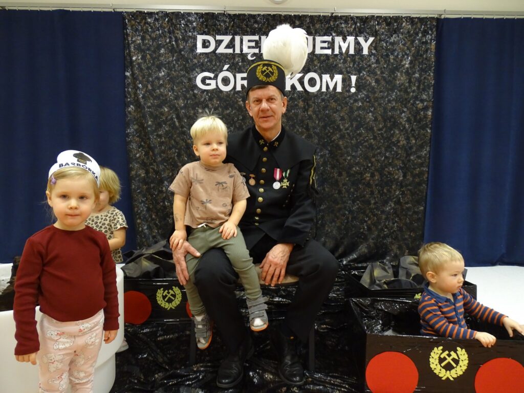 Górnik trzyma chłopca na kolanach