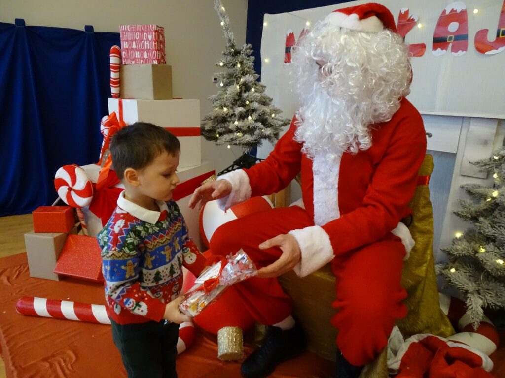 Mikołaj wręcza chłopczykowi prezent