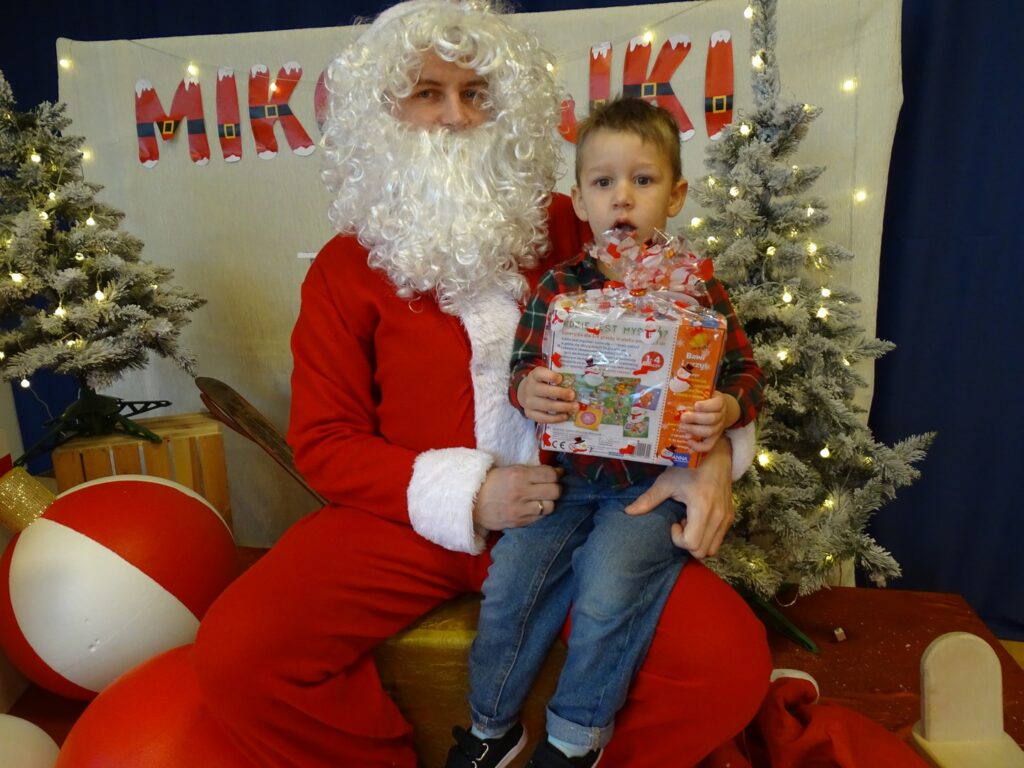 Chłopiec pozuje do zdjęcia z Mikołajem