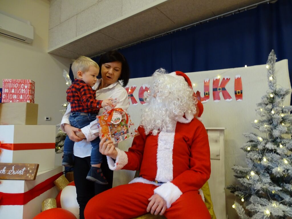 Chłopiec z opiekunem odbiera prezent