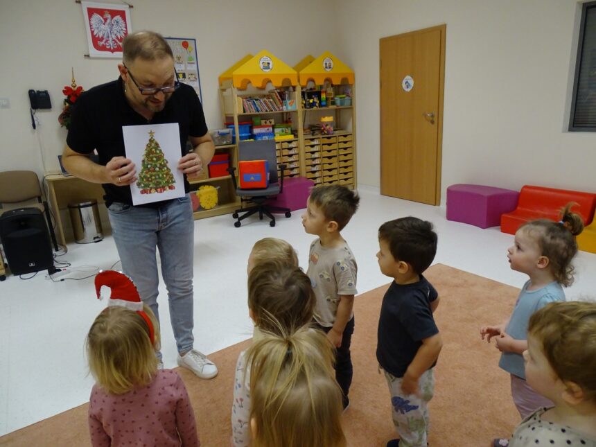 Pan pokazuje dzieciom zdjęcie choinki