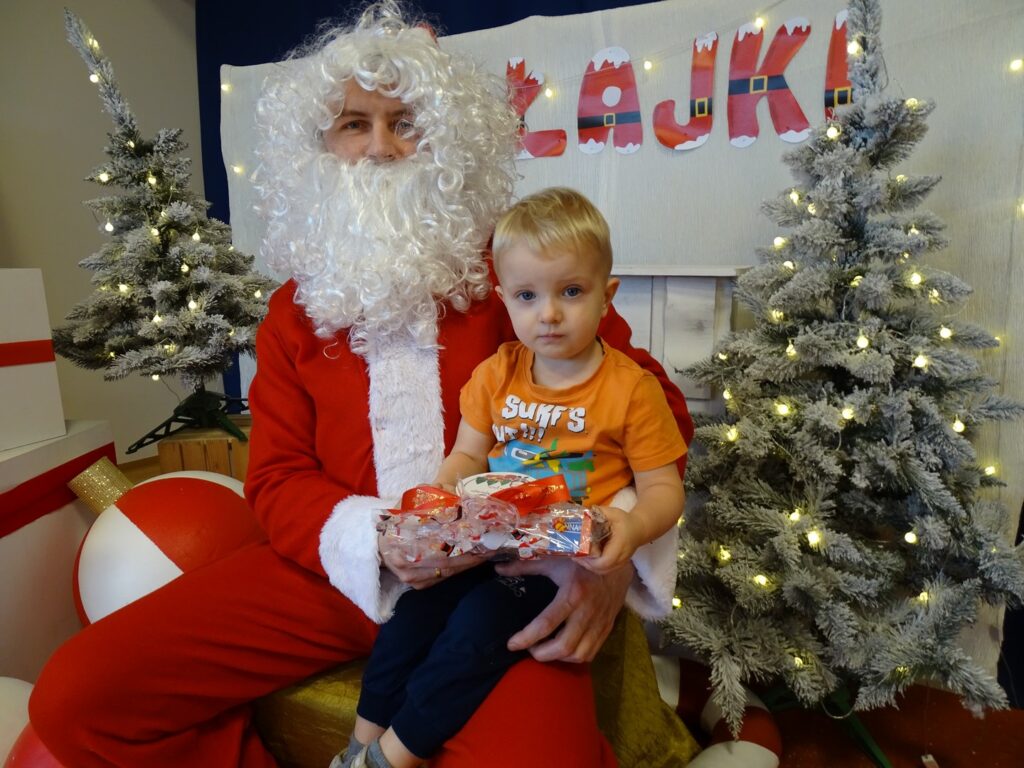 Chłopiec pozuje do zdjęcia z Mikołajem