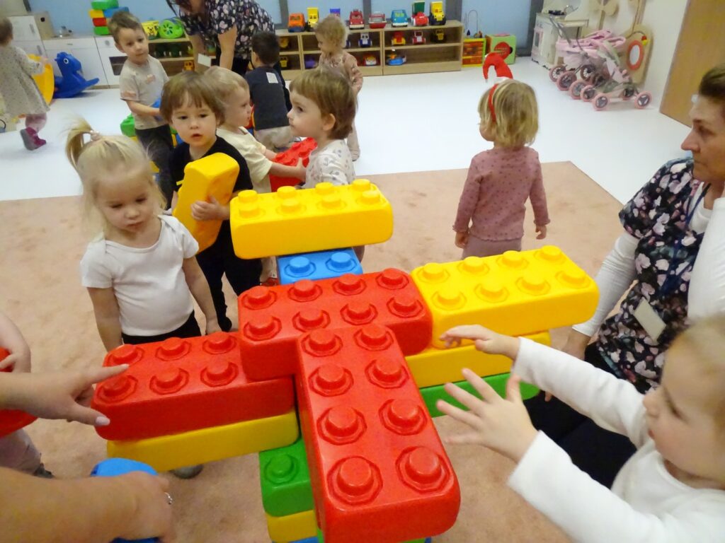 Dzieci tworzą kolorową choinkę z klocków