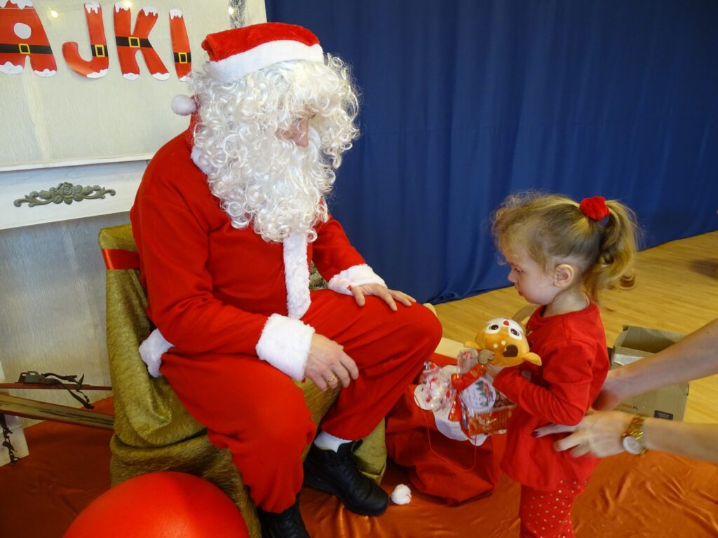 Dziewczynka odbiera prezent od Mikołaja