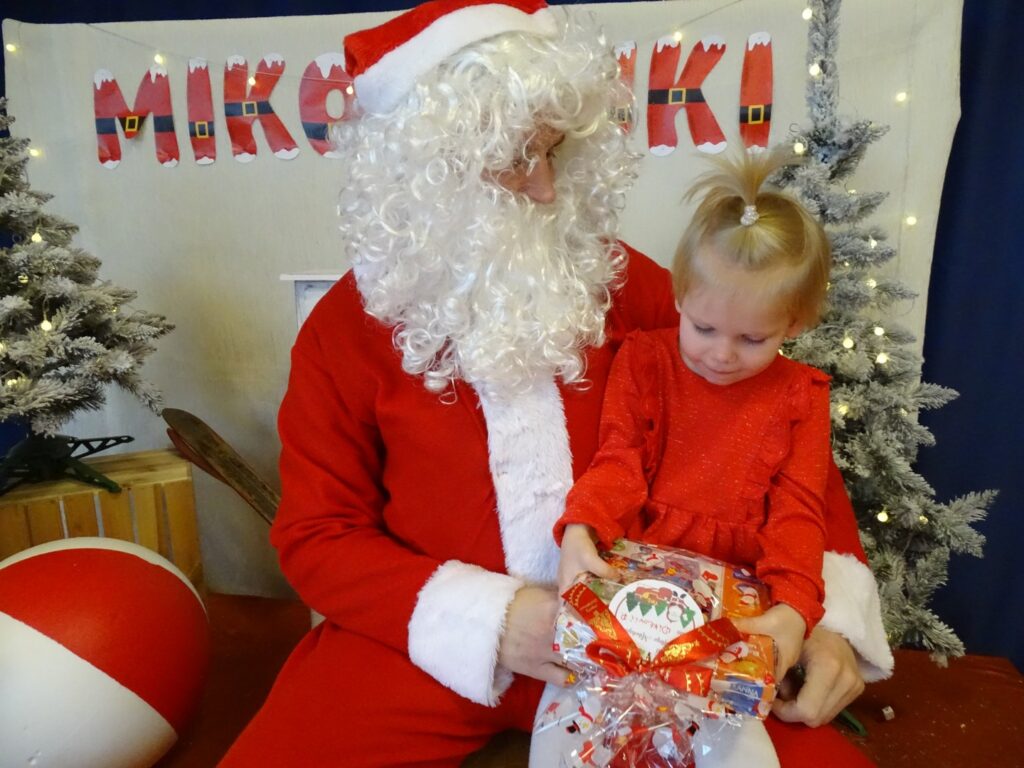 Dziewczynka ogląda prezent od Mikołaja