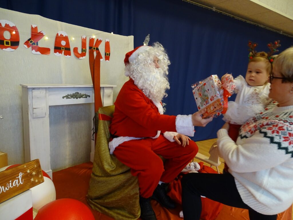 Dziewczynka odbiera prezent od Mikołaja