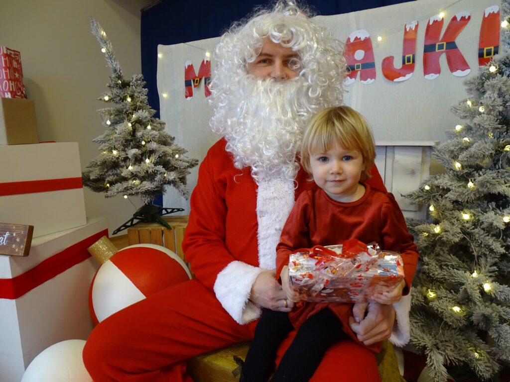 Dziewczynka uśmiecha się do zdjęcia z Mikołajem