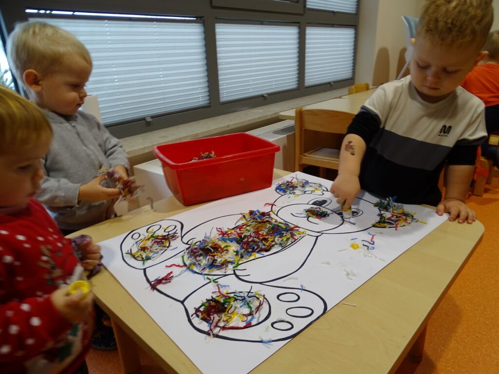 Dzieci wyklejają misia