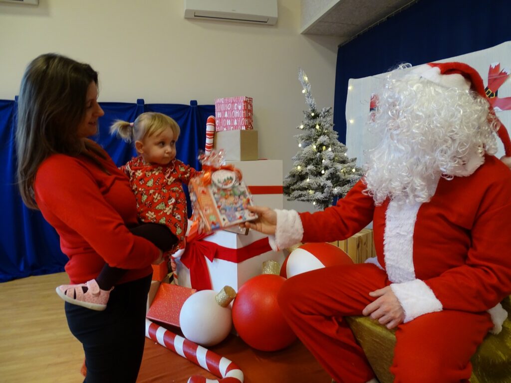 Dziewczynka odbiera prezent od Mikołaja