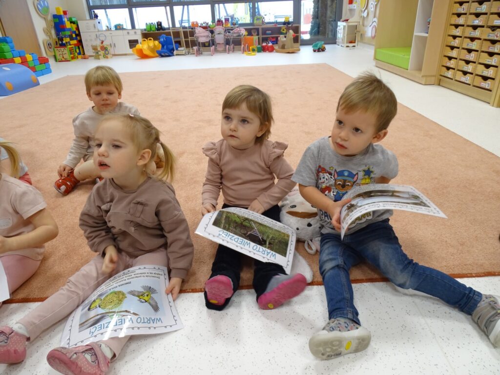 Dzieci słuchają jak dokarmiać zwierzęta zimą