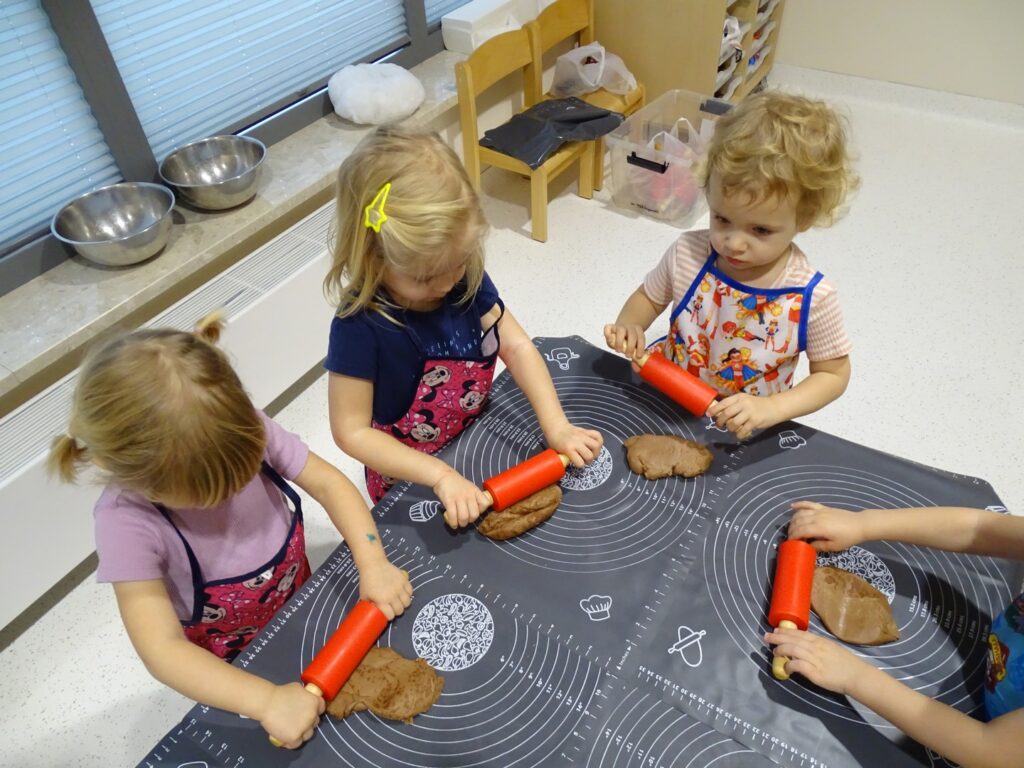 Dzieci wałkują ciasto na pierniczki