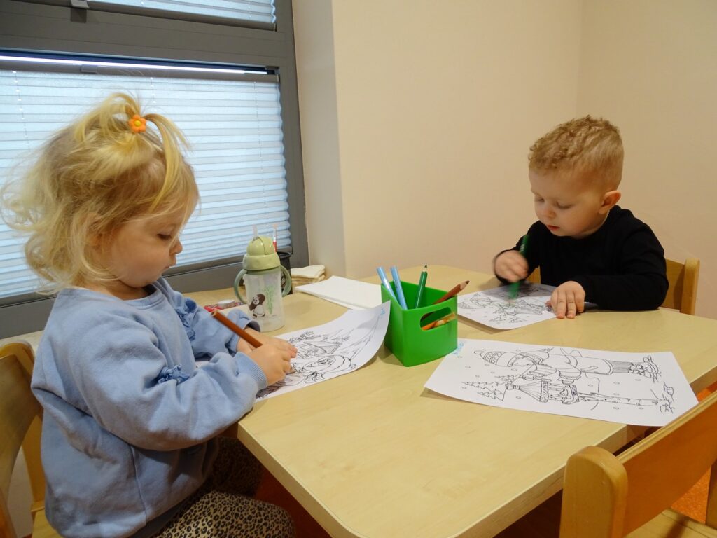 Dziewczynka z chłopcem maluje przy stoliku