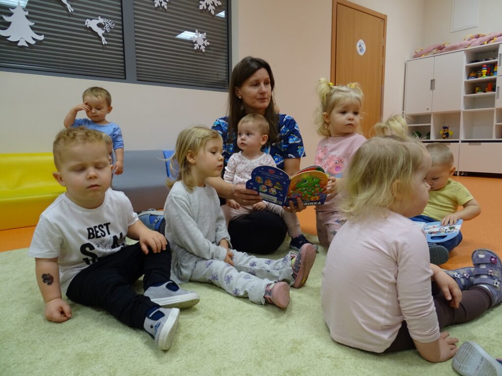 Dzieci siedzą na dywanie