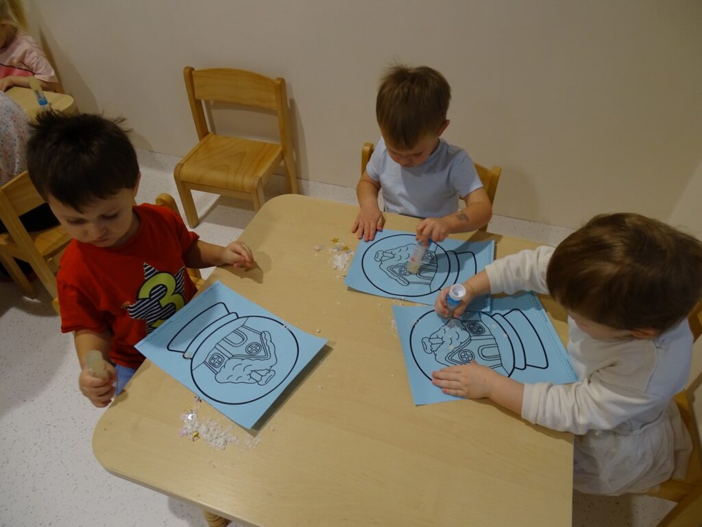 Dzieci smarują obrazek klejem