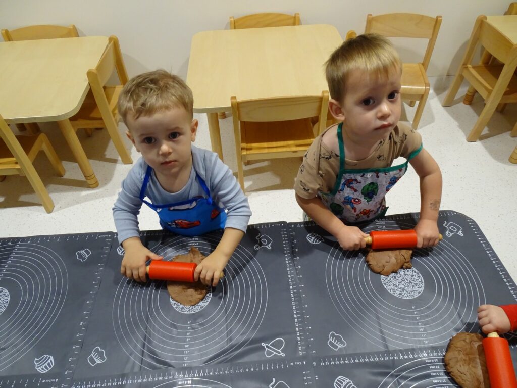 Chłopcy trzymają wałeczki do ciasta