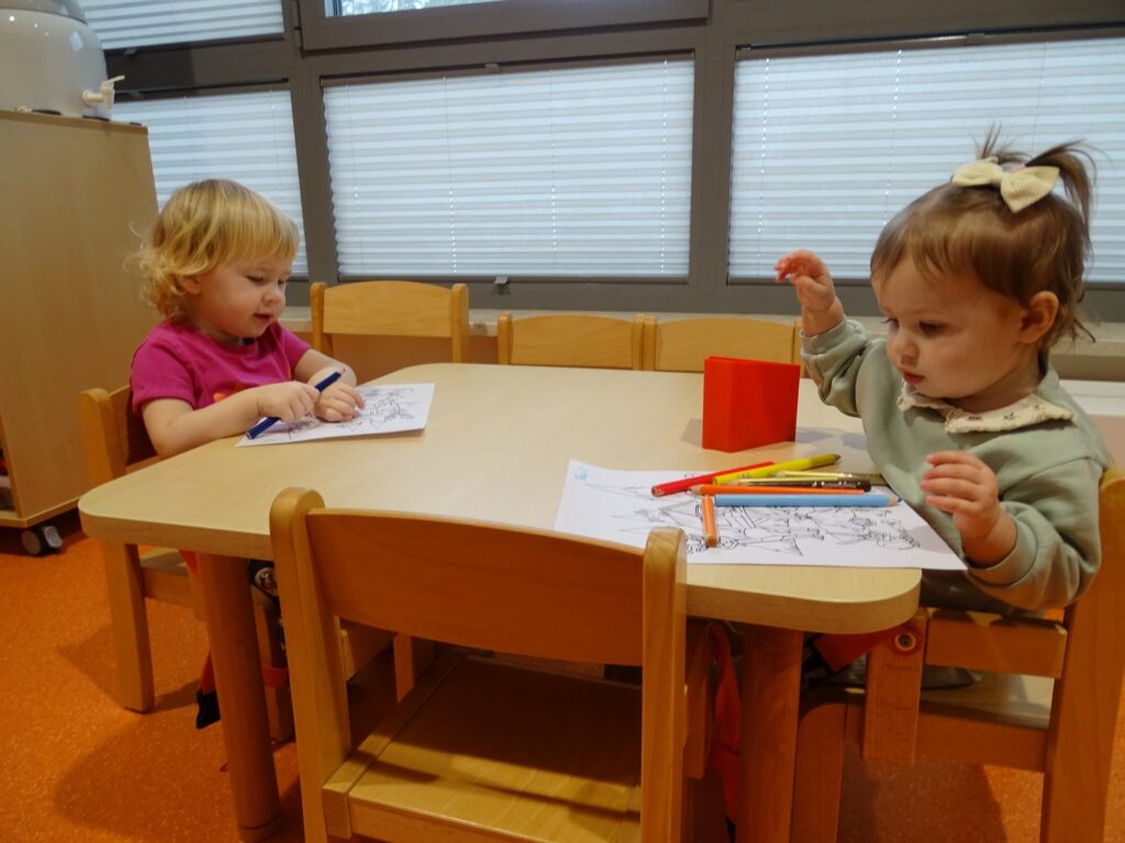 Dziewczynki pracują z kredkami