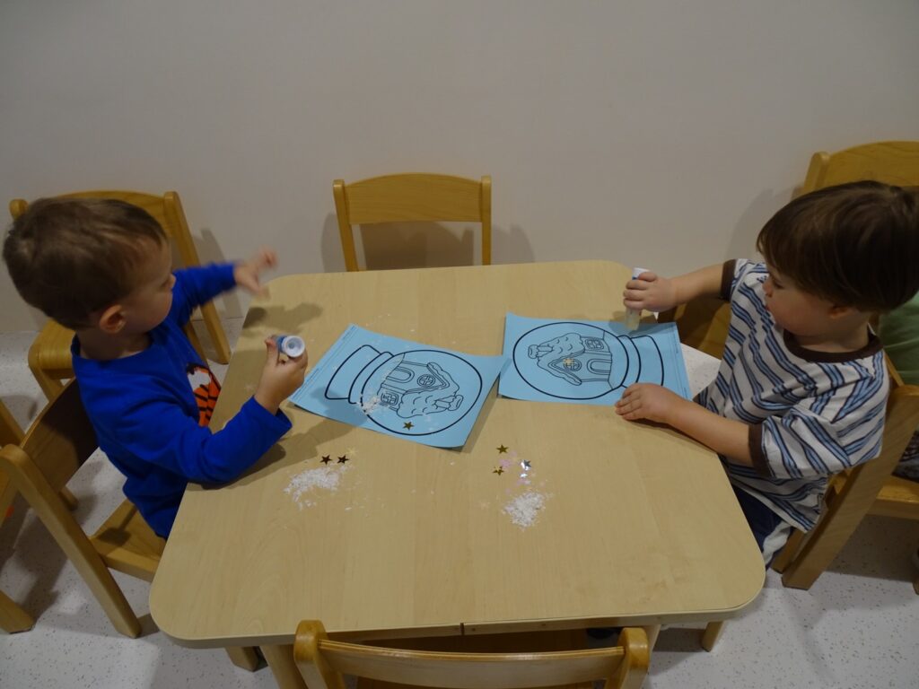 Chłopczyk smaruje klejem obrazek