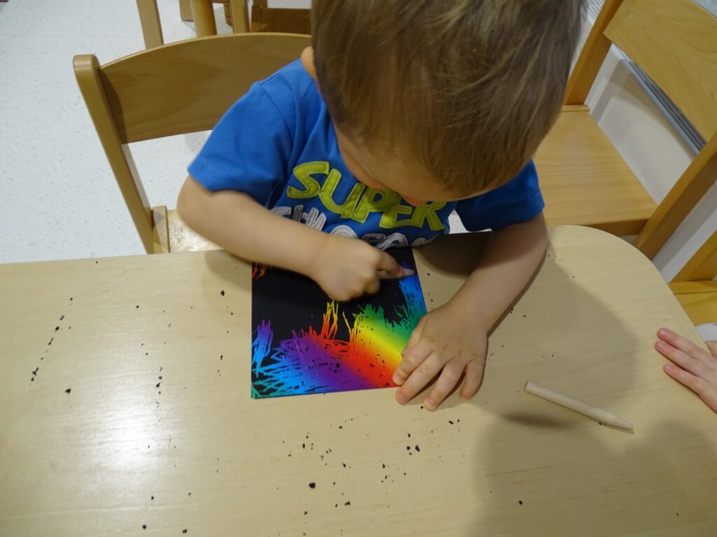 Chłopczyk tworzy wydrapywankę