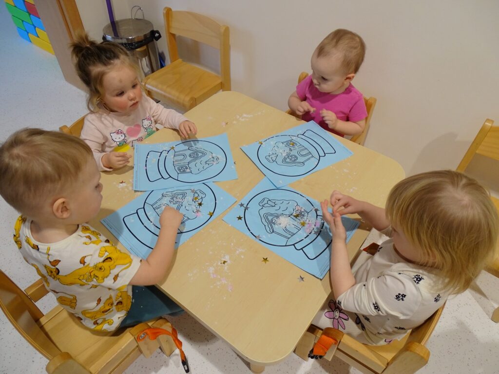 Dzieci wyklejają obrazek klejem