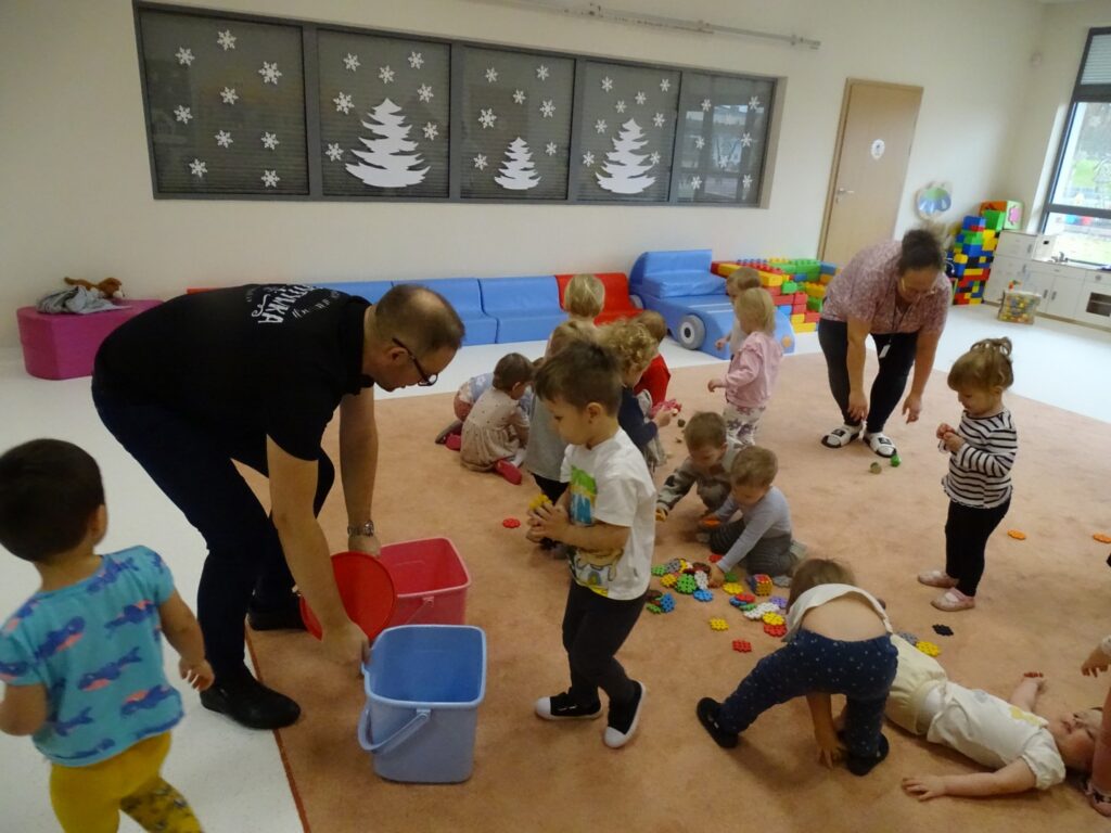 Pan pokazuje dzieciom jak posprzątać