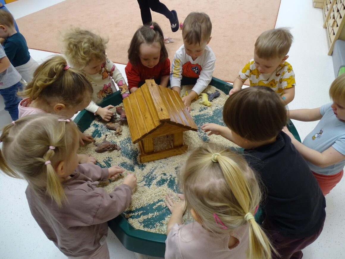 Dzieci wsypują nasionka do karmnika