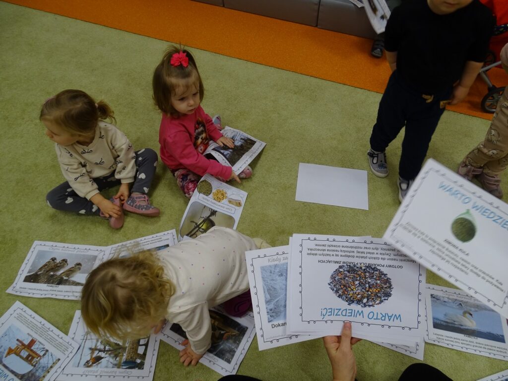 Dzieci wspólnie oglądają karty pracy