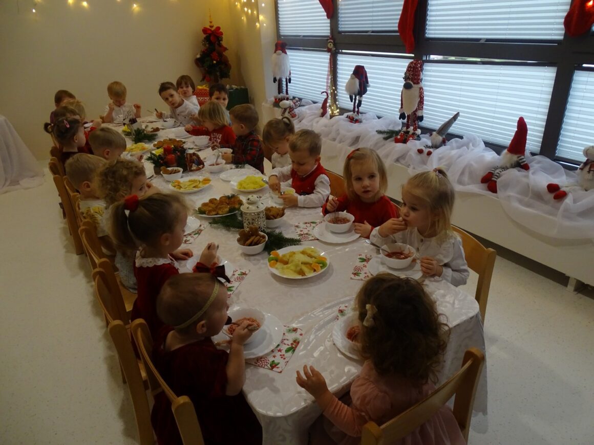 Dzieci jedzą wspólne posiłek wigilijny