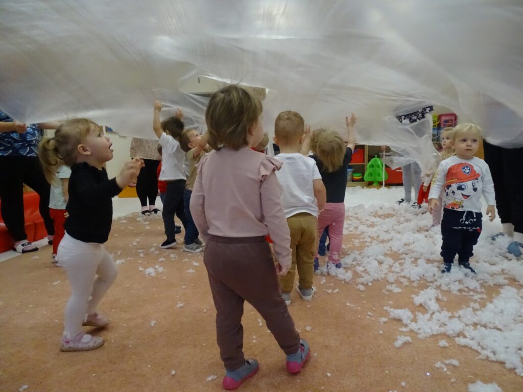 Dzieci chowają się pod folią