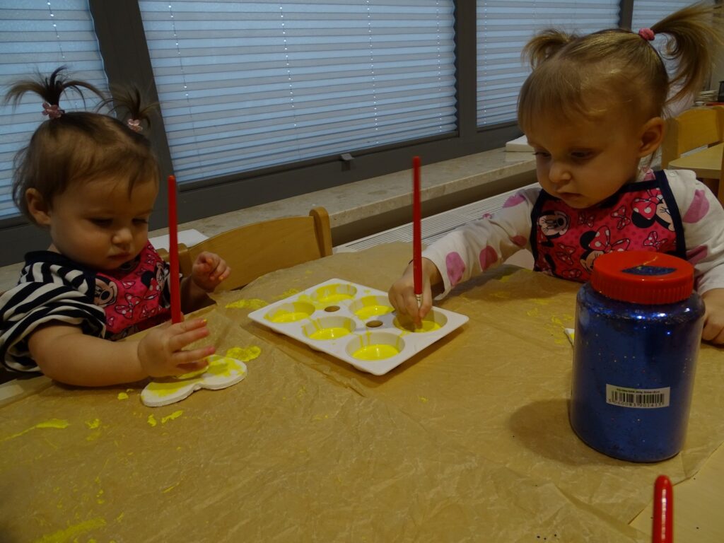 Dziewczynki malują żółtą farbą