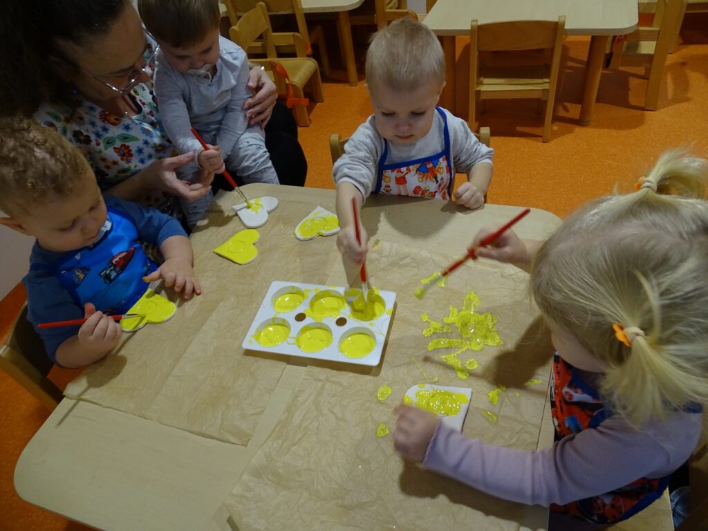 Dzieci malują żółtą farbą