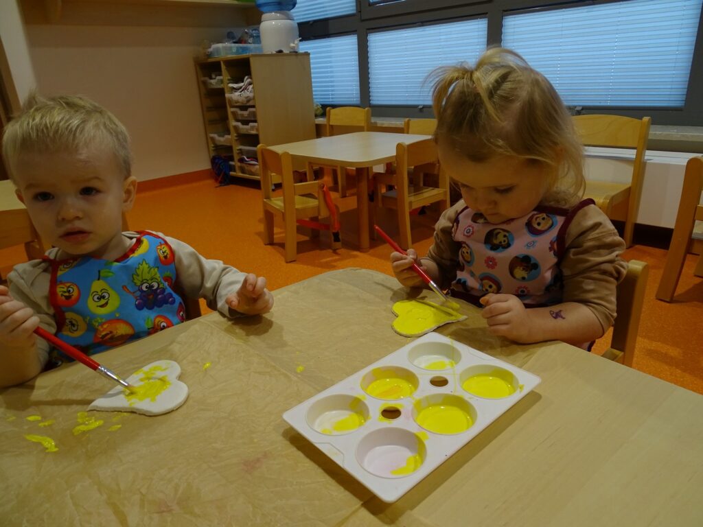 Dziewczynka z chłopcem maluje farbą