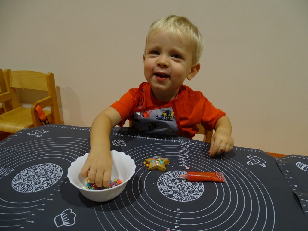 Chłopiec dekoruje pierniczka