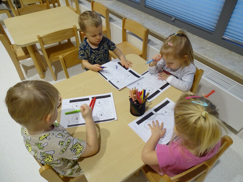 Dzieci zastanawiają się jak pomalować obrazki