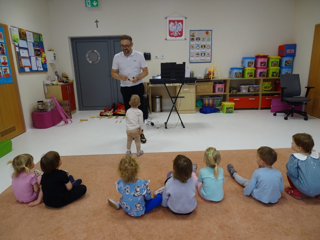 Pan pokazuje dzieciom jak grać na instrumentach