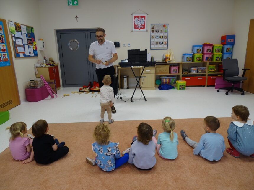 Pan pokazuje dzieciom jak grać na instrumentach