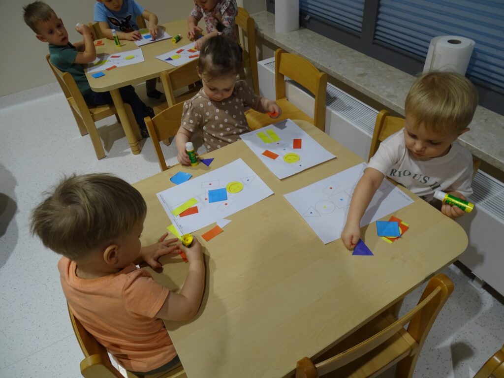 Chłopczyk wybiera figury geometryczne