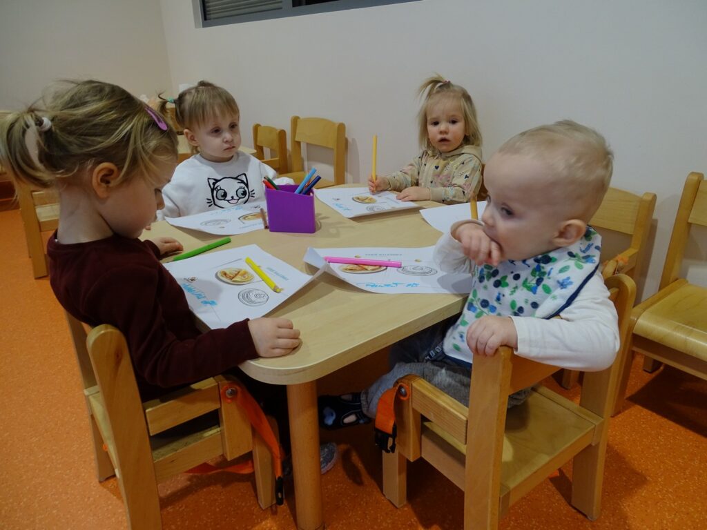 Dzieci kolorują przy stoliku