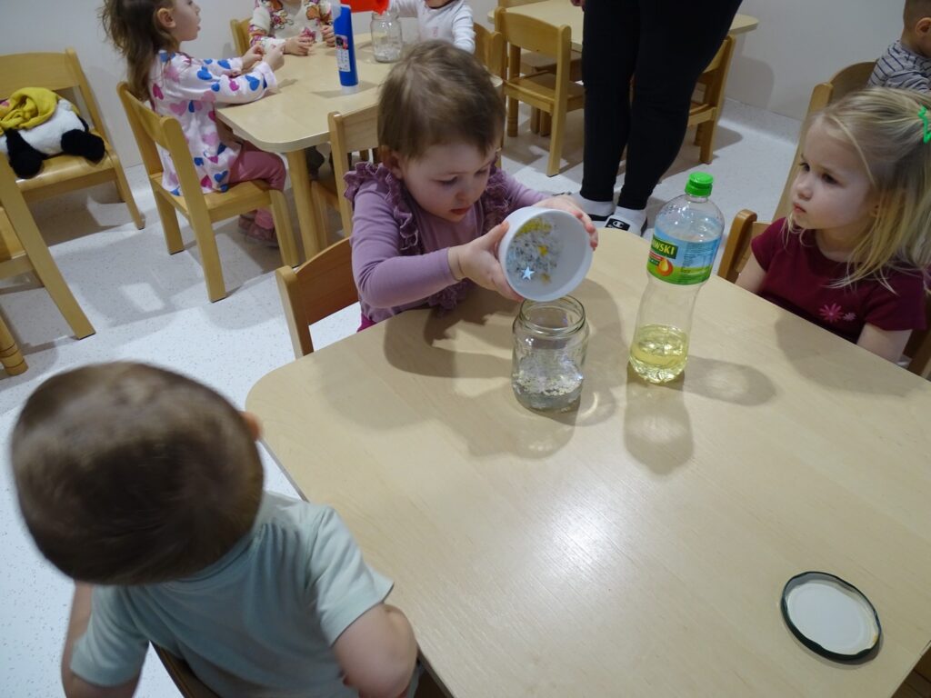 Dziewczynka wsypuje gwiazdki do słoika