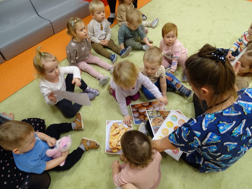 Opiekun przeprowadza zajęcia o Tłustym Czwartku