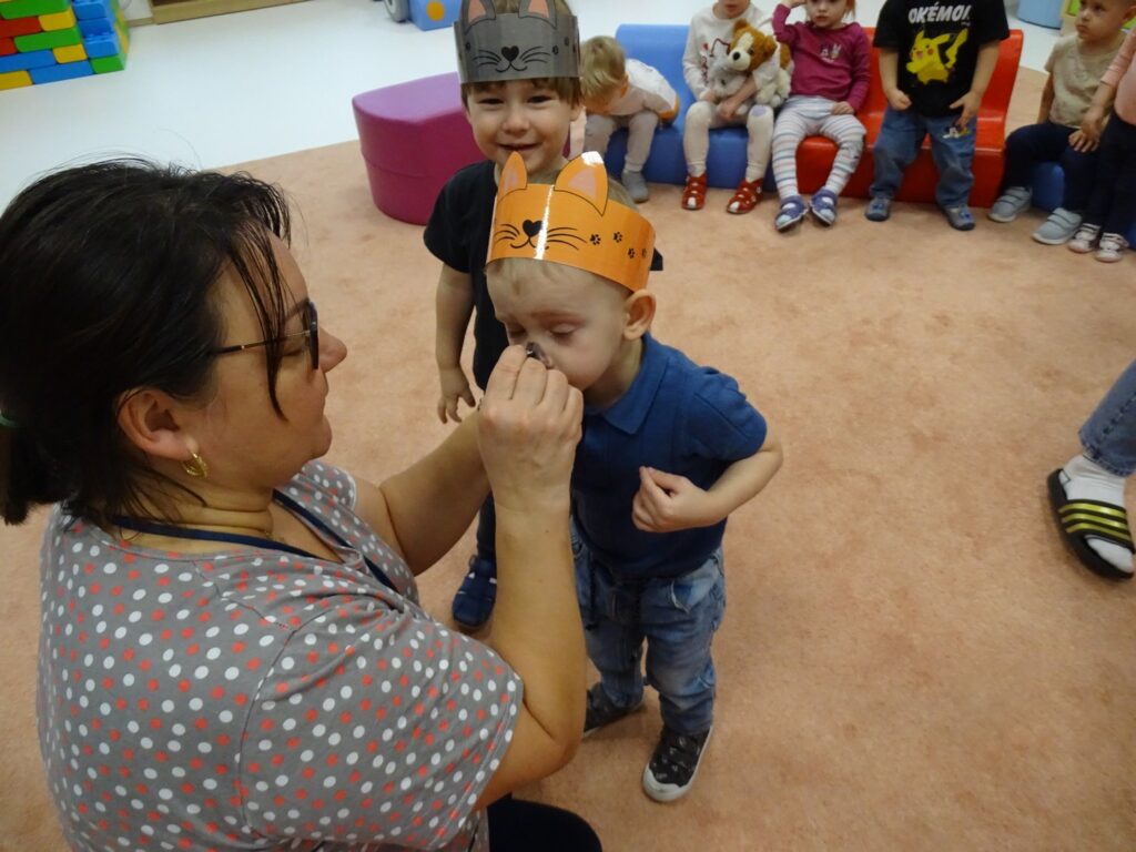 Opiekunka maluje dzieciom wąsiki