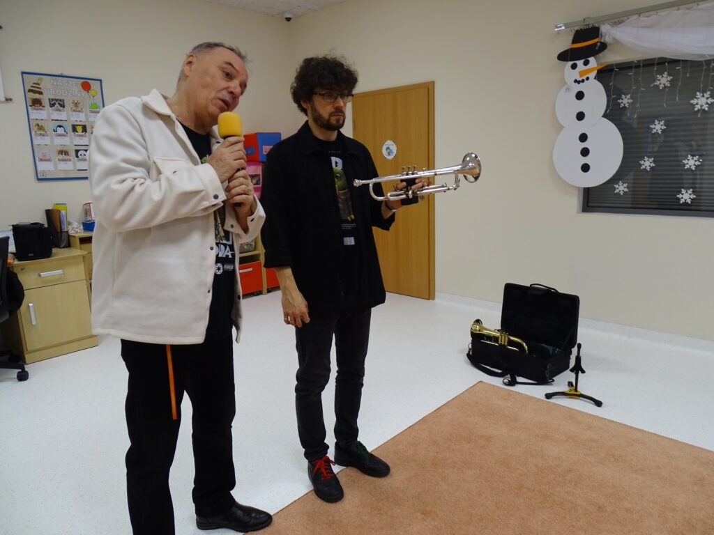 Pan pokazuje dzieciom trąbkę